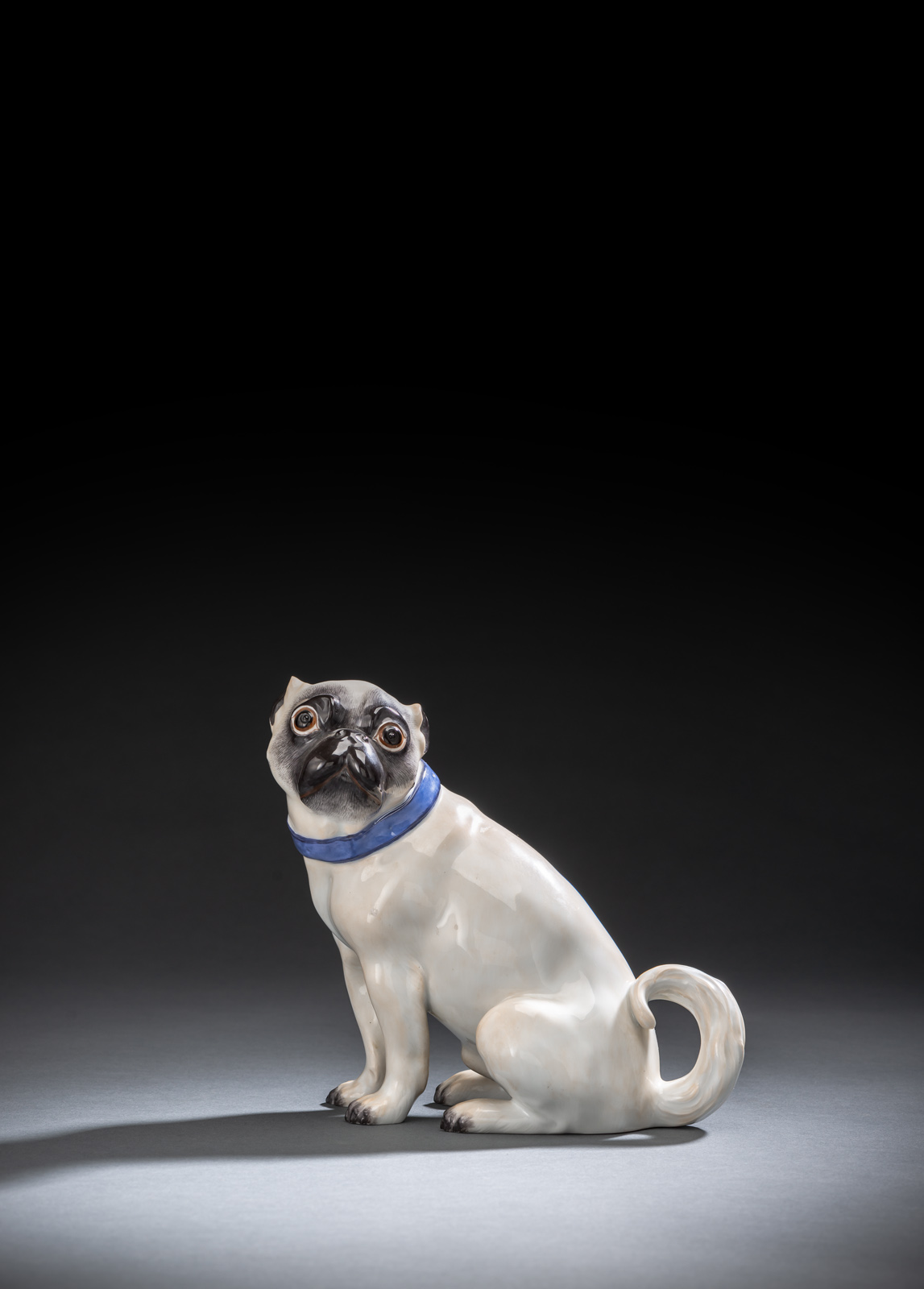 Naturalistisch staffiert mit blauem Halsband. Blaue Schwertermarke (1. Wahl), geritzt 